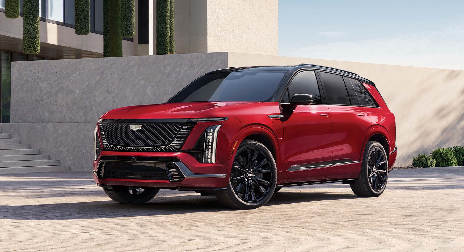 Red Cadillac VISTIQ parked in front of a building