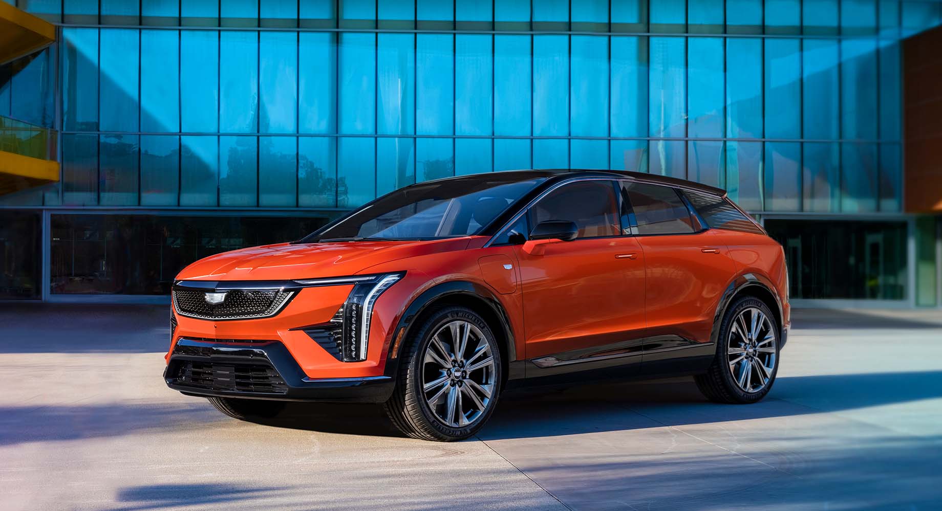 Red Cadillac VISTIQ parked in front of a building