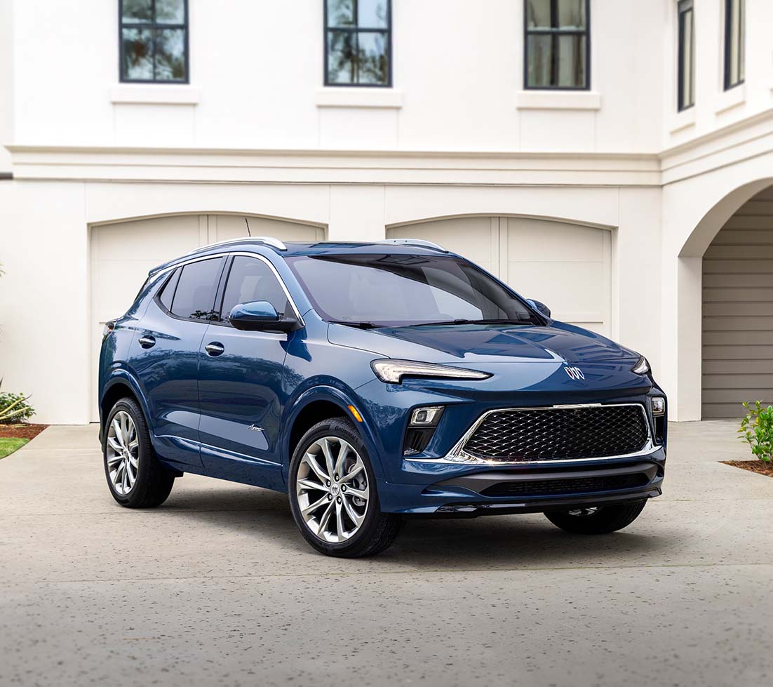 Blue Buick Encore is parked in front of a white house
