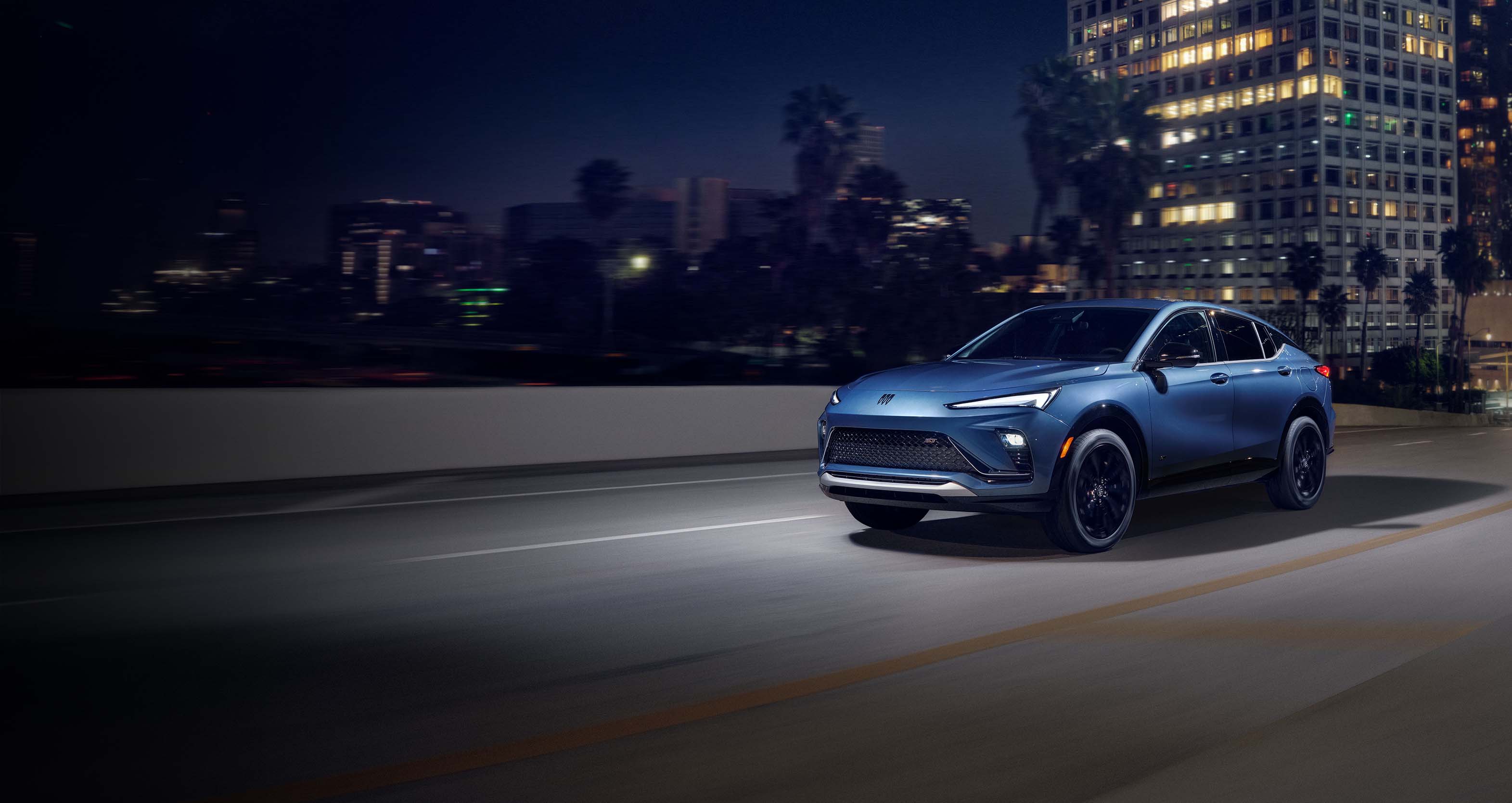 Sleek blue Buick Envista in an urban night scene