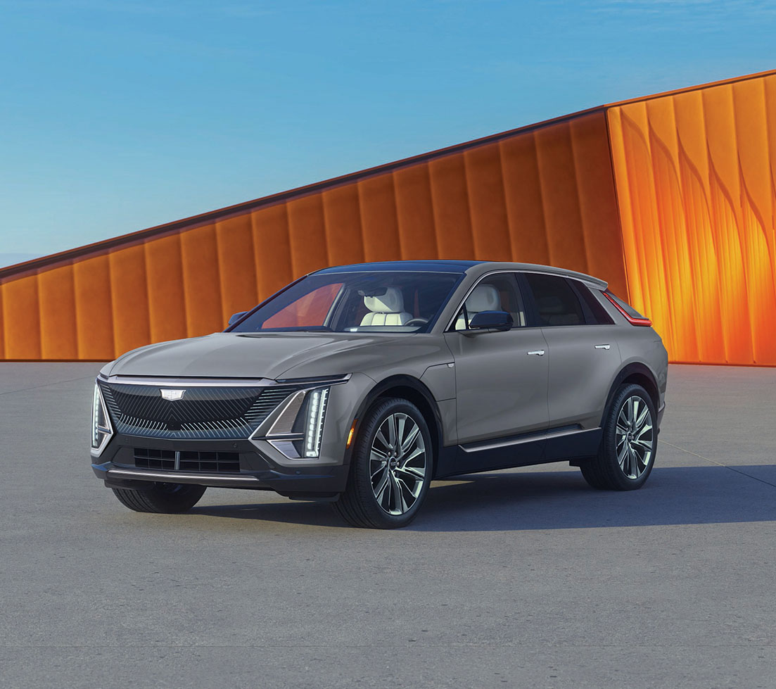 Grey Cadillac LYRIQ is parked in front of an orange building
