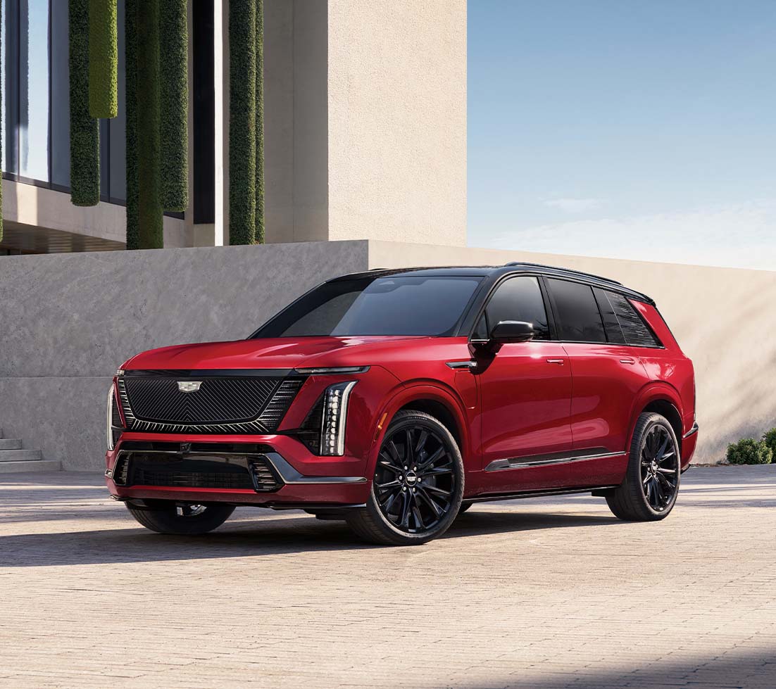Red Cadillac VISTIQ parked in front of a building