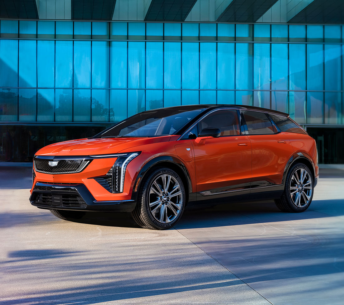 Red Cadillac OPTIQ parked in front of a building