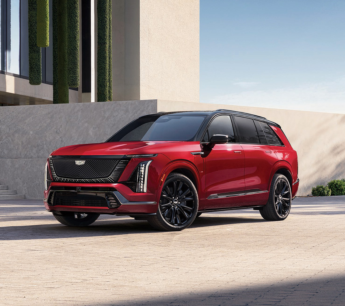 Red Cadillac VISTIQ parked in front of a building