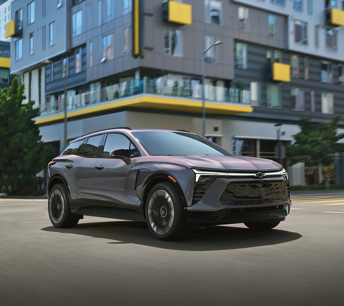 Grey Chevrolet Blazer EV is driving down a city street