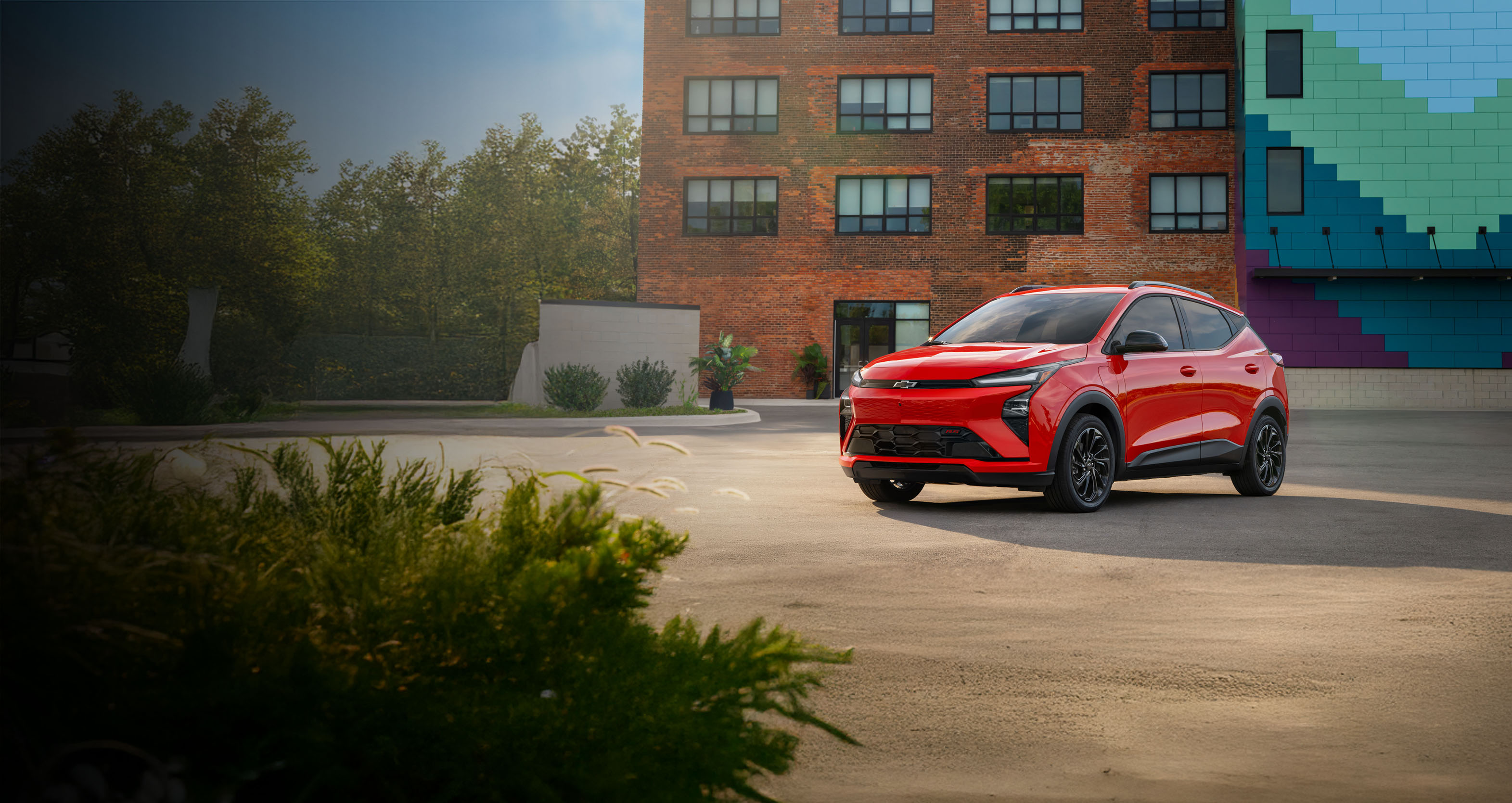 White Chevy Equinox EV driving in front of a brick building