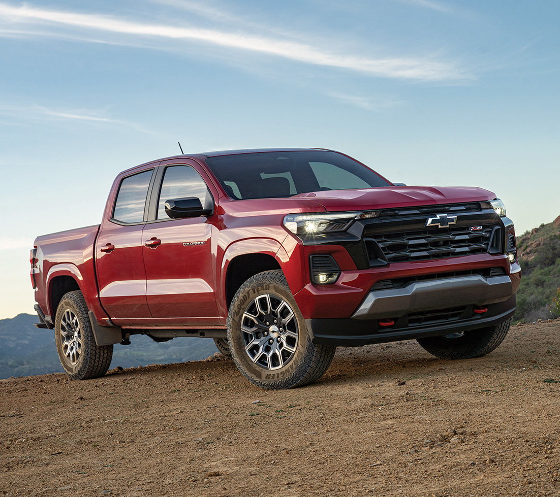 Un Chevrolet Colorado rouge garé sur un chemin de terre