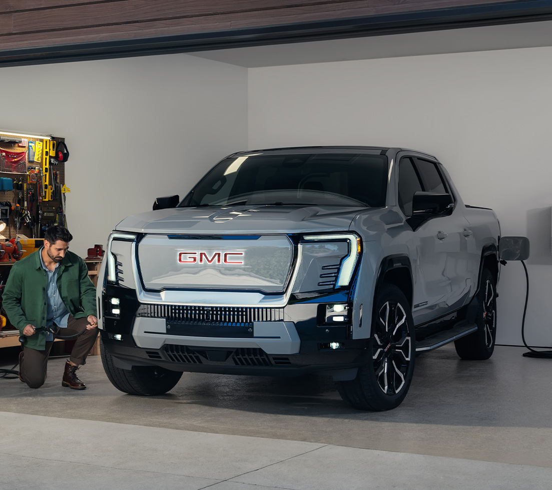 Blue GMC HUMMER EV SUT on a mountain road