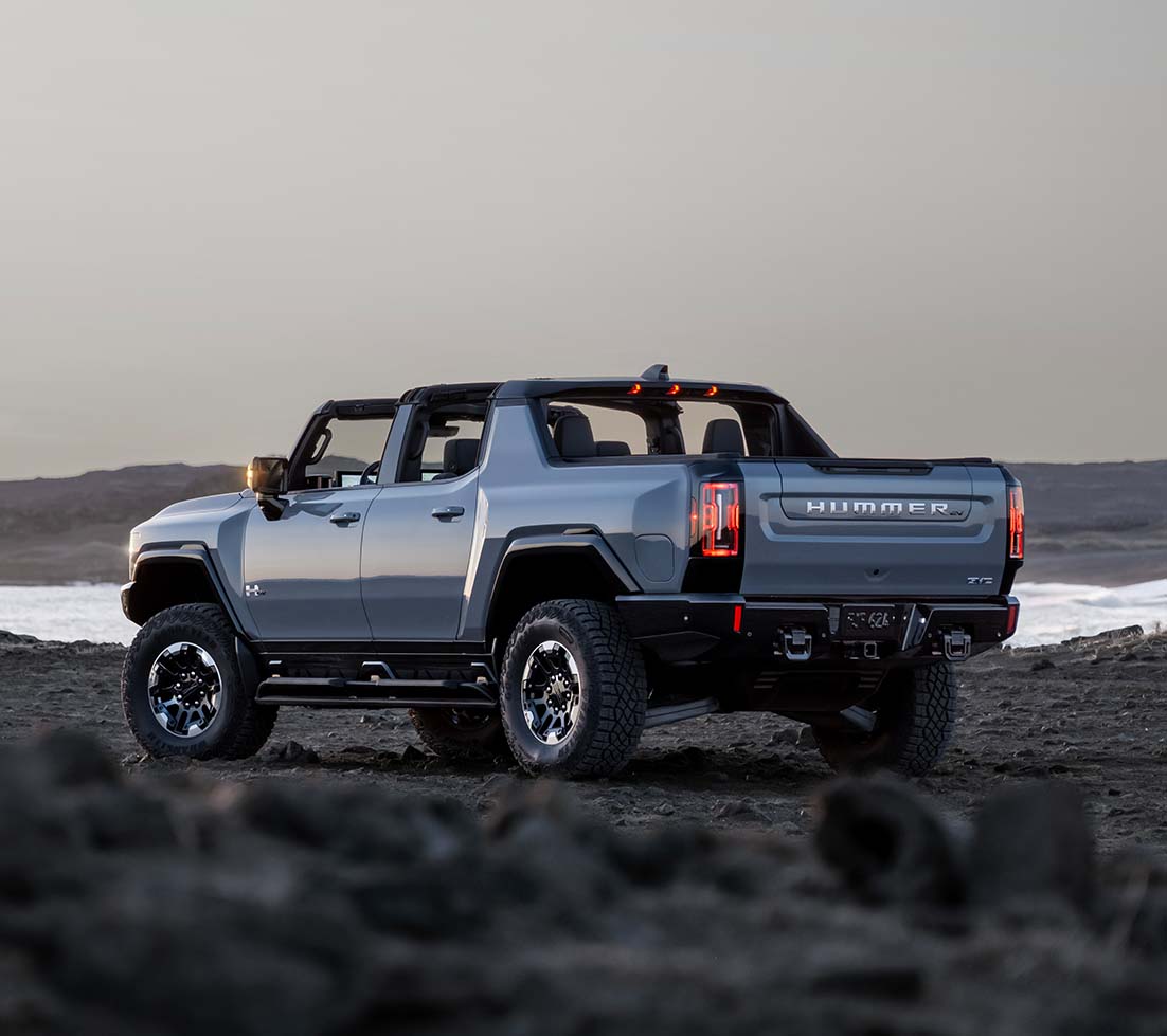 Blue GMC HUMMER EV SUT on a mountain road